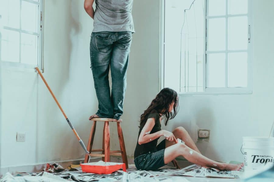 man and woman painting corner of a room